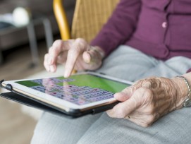 Ältere Frau spielt Solitaire auf einem Tablet