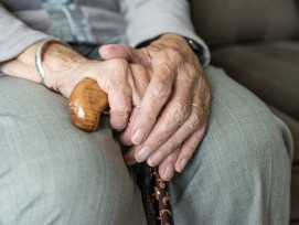 Ältere Frau mit Stock auf dem Sofa