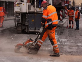 Strassenbau, Arbeiter mit Maschine