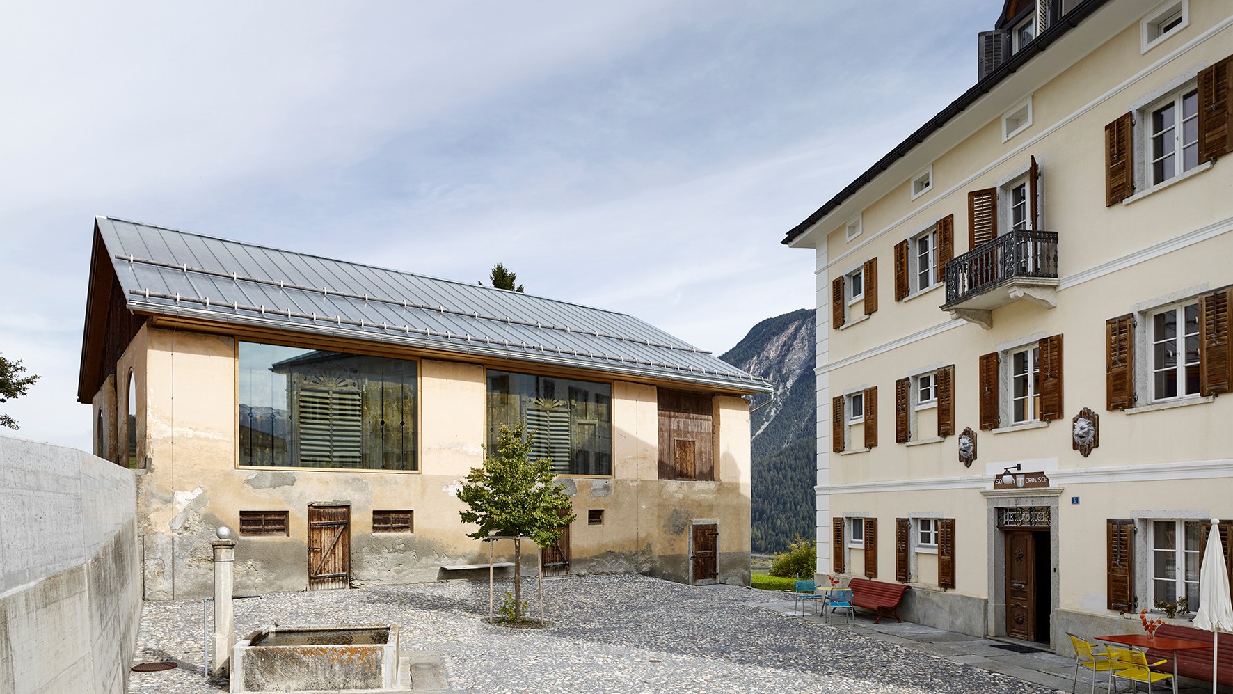 Das ehemalige Anwesen der Familie Carisch: Die umsichtig umgebaute Scheune (links) und die neu bespielte Villa bilden mit dem aufgefrischten Vorplatz ein charaktervolles Ensemble.